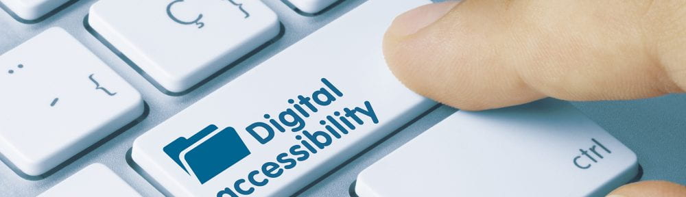 finger pressing digital accessibility button on computer keyboard